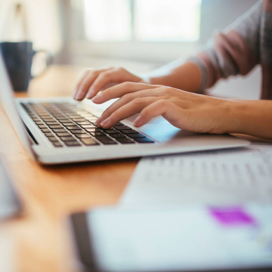 A young person is using a laptop while working and studying at home.