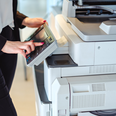 Person clicking on the screen of a large printer. 