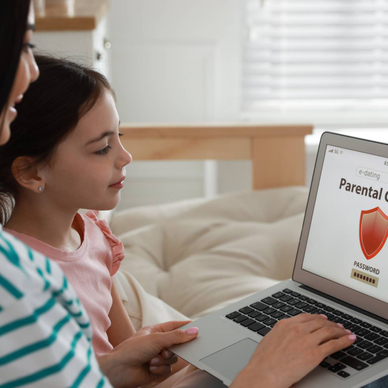 Mom installing parental control on laptop at home.