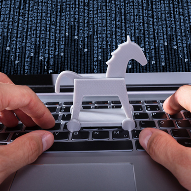Person with Trojan horse icon on laptop affected by virus.