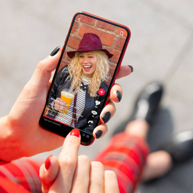 Person holding phone with TikTok content.