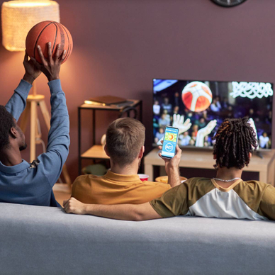 Back view of a group of friends watching basketball match at home