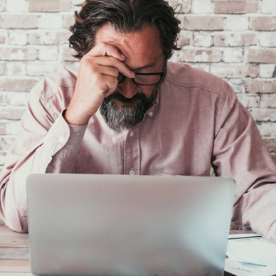 Man working on his laptop looking stressed