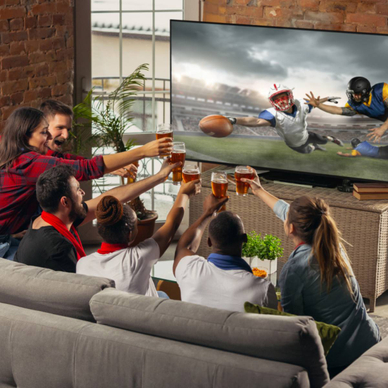 A group of friends in a living room drinking beer and watching a football game on the TV.