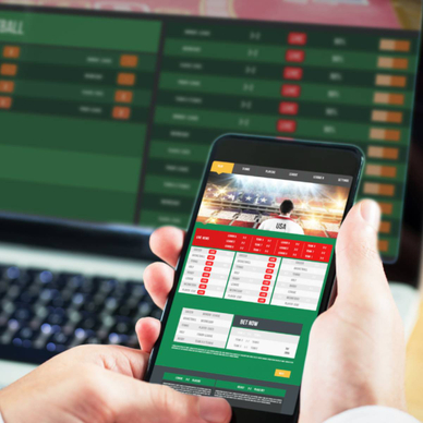 A man using a smartphone and laptop toplay online gambling and sports betting
