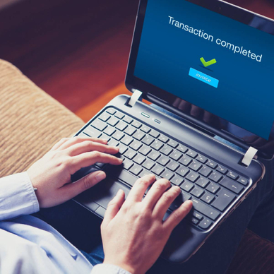 A woman completing a PayPal invoice transaction on laptop