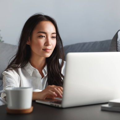 A young woman using her laptop in her living room.