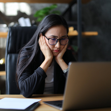 Woman looking at laptop worried