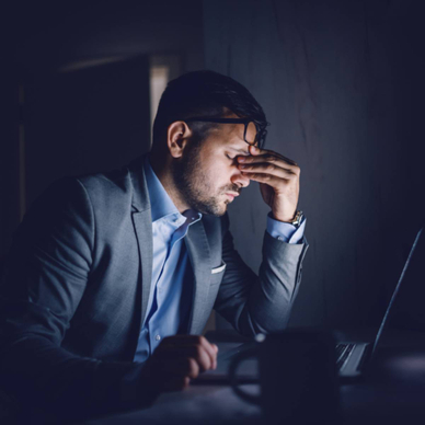 A stressed businessman sitting in front of his laptop
