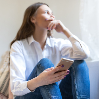 Woman looking concerned holding her phone