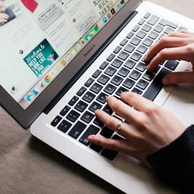 Hands typing on a mac while browsing Pinterest. 