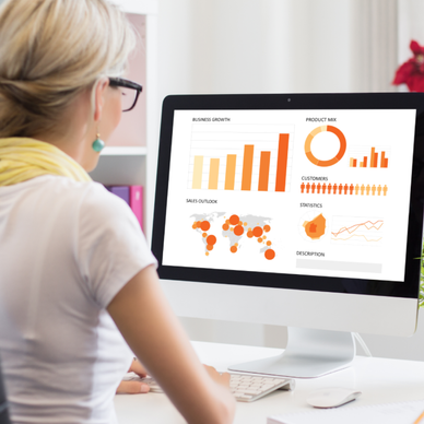 Woman looks at charts and graphs on a mac.