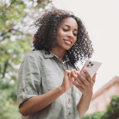 Woman staring down at her iPhone and using it.
