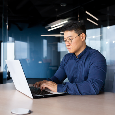 Man types on his computer in an office.