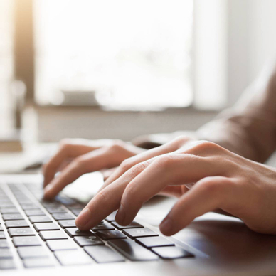A pair of hands typing on a computer.