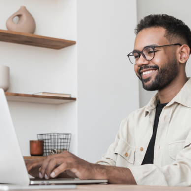Man types on his computer at home.