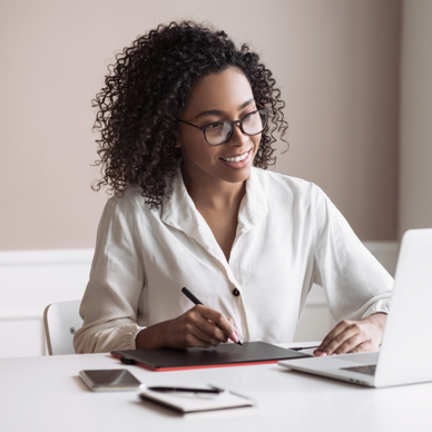 Woman holds a pen while staring at her laptop.