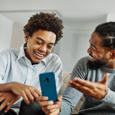 A father shows a phone to his son. 