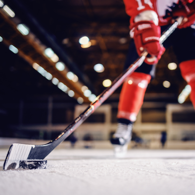 Close up of hockey player skating with stick and puck.