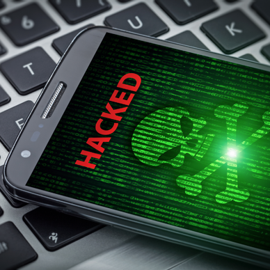 skull of death on smartphone screen. Hacked mobile phone on laptop computer