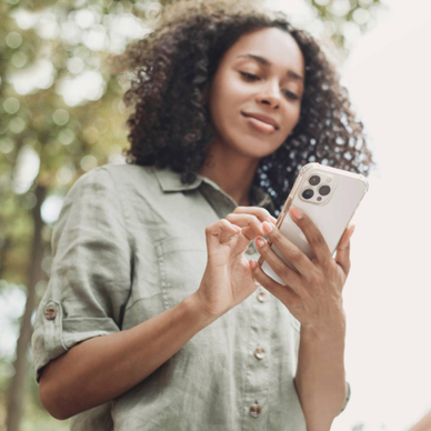 A young woman walking outdoors using her smartphone