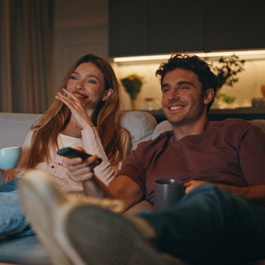 A couple watches TV together.