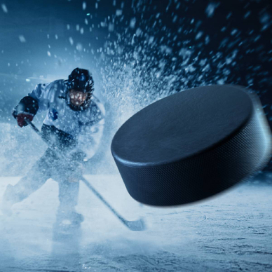 A close up of a hockey puck hurling toward the fore