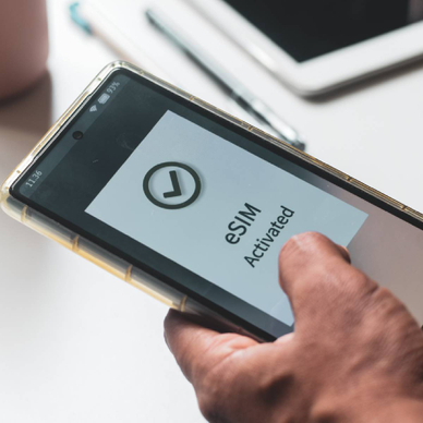 A person&#x27;s mobile phone displaying &quot;eSIM activated&quot;