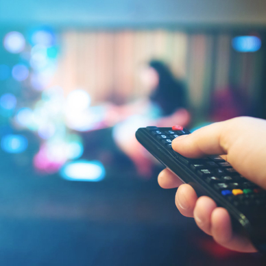 Image of remote being held up to TV