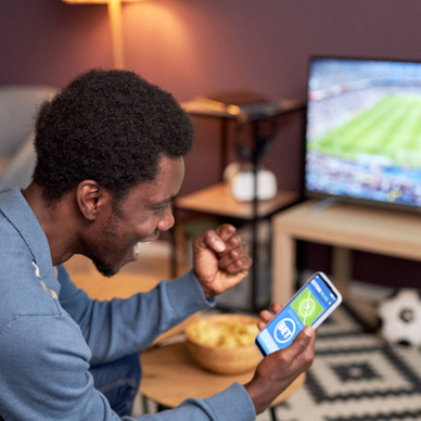 A man cheering while placing NFL bets