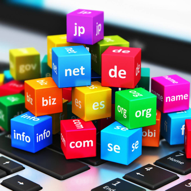domain name concept of TLDs stacked as colored blocks atop a laptop keyboard