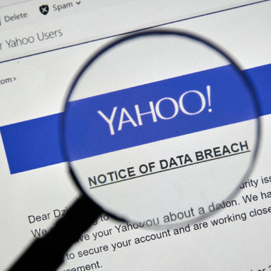 Closeup of a magnifying glass displaying a Yahoo data breach notice