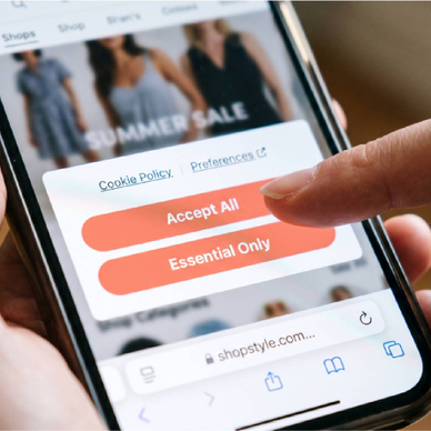 Hand holding smartphone with cookie policy consent popup on screen