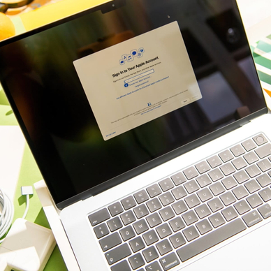 MacBook Air M4 is shown during initial setup process with Apple ID login screen visible.