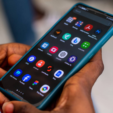 Close-up of a pair hands holding their Android phone looking at a screen of apps