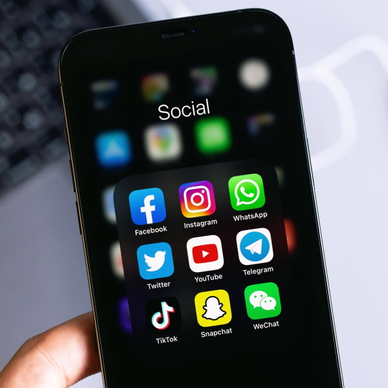 Phone screen open to a social media folder with familiar apps like Facebook and Instagram.