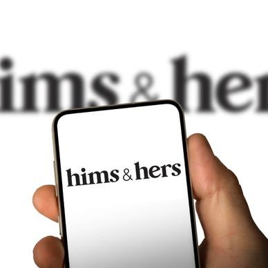 Phone screen with Hims &amp; Hers logo in front of a blurry screen.