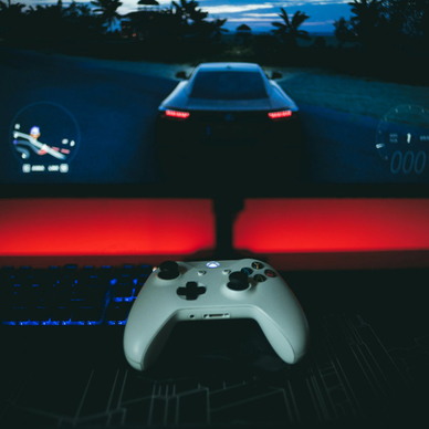 A video game controller sitting in front of a monitor