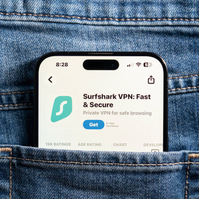 Closeup of back jeans pocket featuring smartphone with Surfshark app market on screen