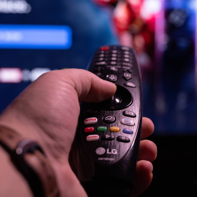 closeup of hand holding an LG smart TV remote