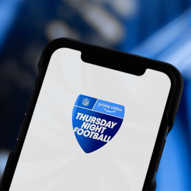 A closeup of a smartphone displaying Prime Video icon with text 'Thursday Night Football'