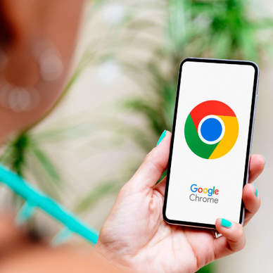 Woman with blue nails holding smartphone displaying Google Chrome logo