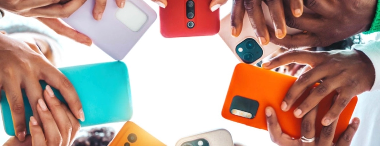 Teens holding cell phones in a circle